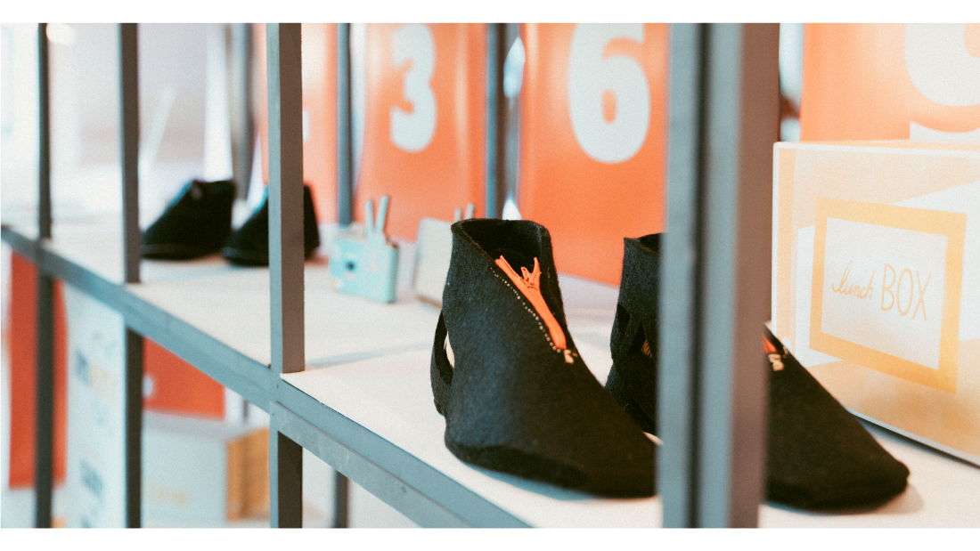 A pair of felt shoes made by students in an exhibition space.